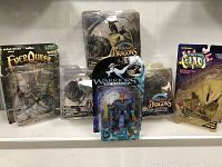 Photo showing all six figures in packaging arranged on a shelf, four McFarlane's Dragons, one EverQuest, one Warriors of Virtue.