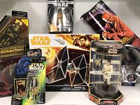 Full view of the lot showing various Star Wars action figures including a TIE Fighter vehicle in box, multiple boxed action figures including Disney Store Force Link 2.0 Finn figure, and a Star Wars CommTech figure.