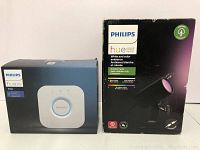 Philips Hue Bridge and Outdoor Spot Lily packaging front view showing product images and branding.