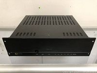 Front view of black Sonance Sonamp 1230 amplifier showing power knob and LED indicators for power status and channel pairs.