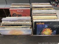 Photo showing multiple vinyl records in two crates with various album covers visible