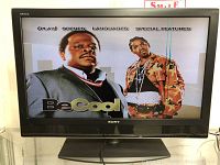 Sony Bravia 40-inch LCD TV powered on showing the menu screen with two men and the title 'Be Cool'. Vertical lines visible on the right side of the screen.
