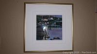 Framed art print showing dockside scene with house, boats, and water in soft colors