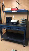 Full front view of Mastercraft metal workbench with items on top and two drawers visible.