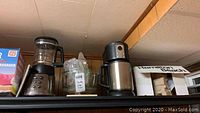 Photo showing Cuisinart blender and Hamilton Beach coffee maker on shelf, next to other items