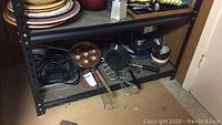 Shelf with plates, bowls, kitchen utensils underneath