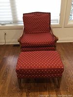 Front view of red upholstered chair and matching ottoman, showing maple wood arms and legs.