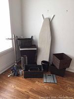Full view of lot items including ironing board, baskets, towel holder, scale, and iron on floor