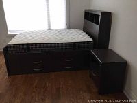 Full view of bed frame, mattress and nightstand from front left angle