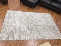 Full view of the rectangular rug laid on wood floor, showing overall pattern and condition