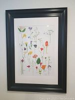 Framed botanical floral print in black frame, showing full artwork and frame.