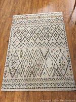 Full view of the rug laid flat on a hardwood floor