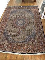 Full view of rug laid flat on hardwood floor showing overall pattern and condition