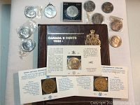 Ten Churchill crown coins arranged around plaque and pendant, plus medallion card and nickel folder