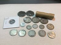 All coins laid out on flat surface showing variety and roll of dimes