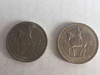 Three 1953 British Five Shilling crown coins laid out on a white surface showing Queen Elizabeth II on horseback.