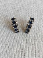 Front view of both earrings showing alternating sapphires and diamonds in a linear arrangement