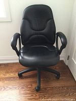 Front view of the black office chair showing padded backrest and armrests