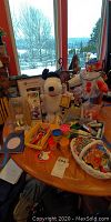 Photo showing all items on a table including clown figurine, Play-Doh, crayons, Snoopy plush, Mariners Ichiro figurine in packaging, basket with small items, key chains, and magnets.