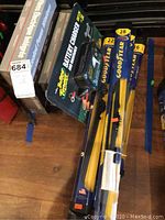 Photo showing new Goodyear windshield wipers sizes 16, 22, 28 inches and Deftran Battery Tender charger on wooden floor.