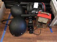 Photo showing Marquette AVR Tester, PowerStation jump starter with tire inflater, and two black HJC DOT helmets on floor