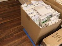 Box filled with many units of Plugable USB Serial Adapters in their original white retail boxes