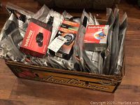 Box containing 23 new Ergodyne knee sleeves individually packaged, along with boxed Bodybug and Omron devices.