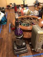 Front full view of Dyson vacuum cleaner upright, showing cyclone assembly, dustbin, and vacuum base.