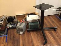 Wide view showing projectors, stand, and boxes of miscellaneous items on floor