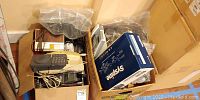 Box of various telephones including Syspine IP Phone 300 Series box, vintage phones, and cords.