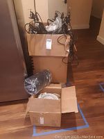 Large box filled with numerous shop lights with visible electrical cords coiled up.
