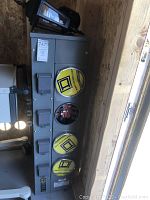 Full view of meter center and outdoor lantern against plywood wall