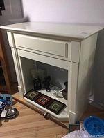 View of white fireplace mantle with decorations inside