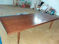 Side angle showing full length and tapered legs on carpet