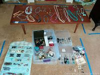 Coffee table with necklaces including beaded, faux pearl, chain and pendant styles