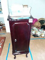 Front view of wooden jewelry cabinet with closed door