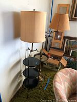 View of both floor lamps side by side showing shelving and lamp shades
