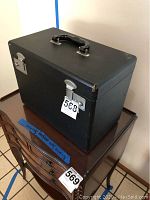 Closed black carrying case on wooden furniture