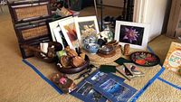 Overview of framed floral prints, wooden bowls, ceramic vase, wicker cases and placemats