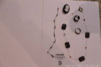 Full jewelry lot laid out: cameo pin, two rings, necklace, ankle bracelet, matching earrings.