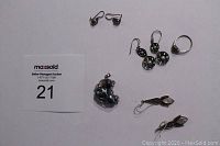 Full lot shot showing all earrings, pendant, and ring on white surface with lot tag.