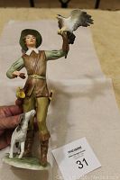 Full view of the porcelain figurine showing boy holding falcon and dog at his feet