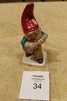 Full view of the ceramic Goebel gnome figurine named 'NIELS' playing guitar, standing on carpet.