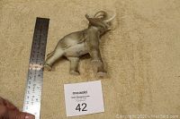 Elephant figurine standing on carpet with ruler to show size approximately 5 inches tall.