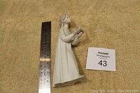 Full side view of the girl holding the candle figurine with ruler for scale showing about 9 inches height.
