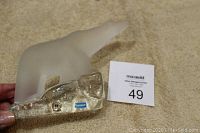 Photo showing frosted crystal polar bear figurine standing on a clear base with 'HANDMADE' and brand stickers visible.