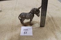 Full side view of the German Kaiser porcelain donkey figurine with a ruler showing approximately 6 inches in height.