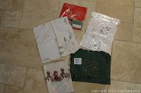 Top-down view showing all five folded table cloths including one in original plastic packaging