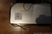 Silver Citizen DVD player on wooden surface with connected RCA cables.