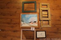 All included frames and the oil painting laid out on wooden floor.